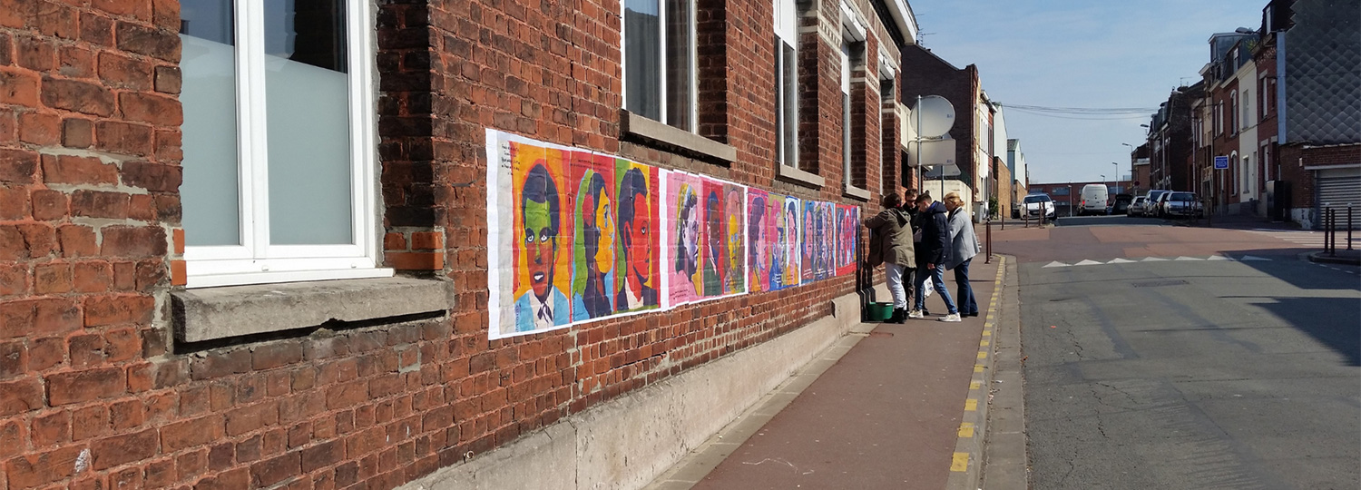 Affiches colorées collées sur un mur en brique