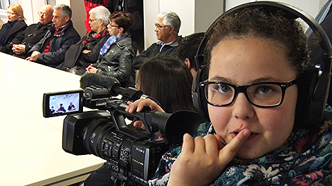 Une enfant un doigt sur la bouche pendant un tournage vidéo